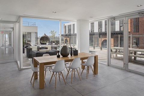 a dining area with a wooden table and chairs and glass doors